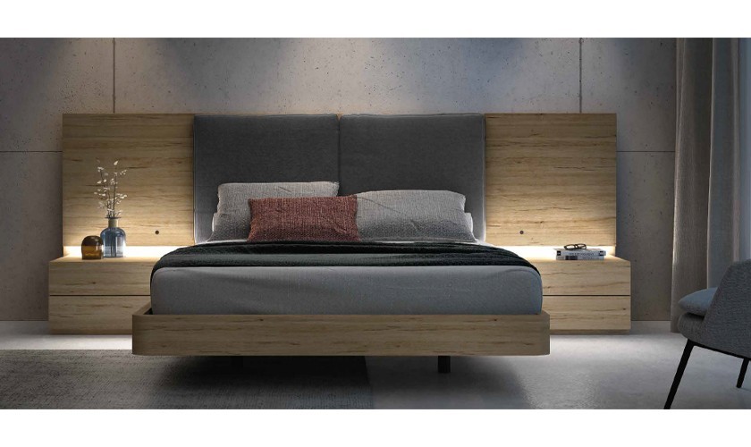 Dormitorio  compuesto de cabecero, canapé y dos mesitas, tapizados en color gris oscuro y con acabados en madera